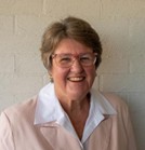 Portrait of Adjunct Professor Debra Thoms wearing a light‑coloured blouse, photographed against a plain background.